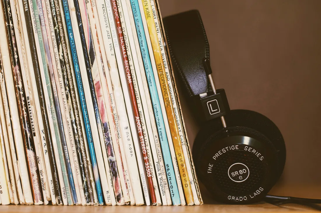 Coleção de discos de vinil ao lado de um fone de ouvido